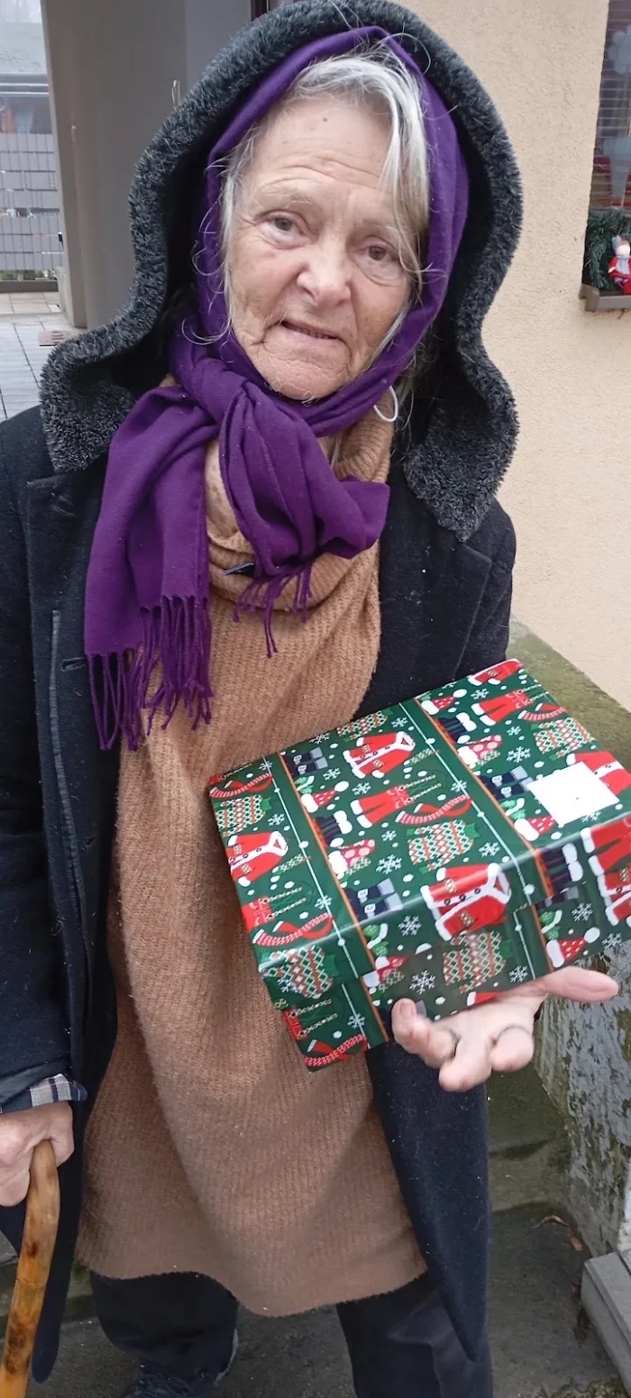 Seniorka prijíma vianočný balíček od dobrovoľníkov Charity Senec